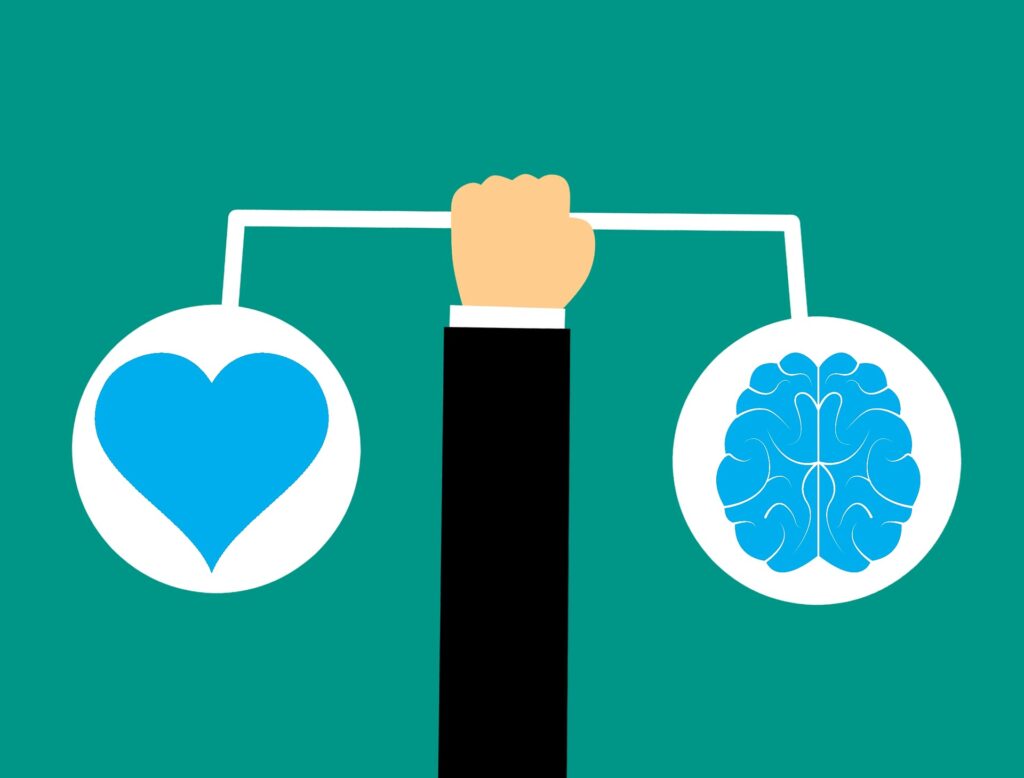 Um braço erguido equilibrando o coração e o cérebro, para representar a inteligência emocional.